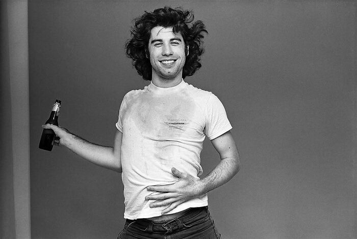 A man in a vintage photo, smiling with a bottle in hand, capturing a moment from the past.