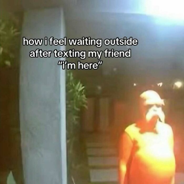 Man waiting outside illuminated by a porch light, capturing a relatable meme moment.