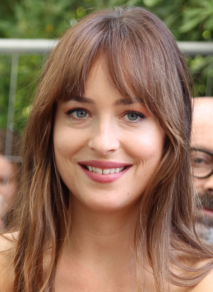 Smiling woman with long hair outdoors, highlighting not-self-made-celebs topic.