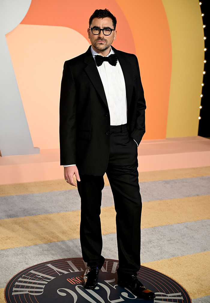 Dan Levy in tuxedo and glasses on Oscars after party red carpet, representing nepo babies presence. Dan Levy in tuxedo and glasses on Oscars after party red carpet, representing nepo babies presence.