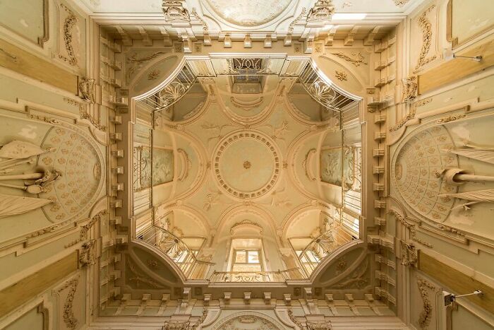 Ornate ceiling of an abandoned building, showcasing beautiful architectural details.