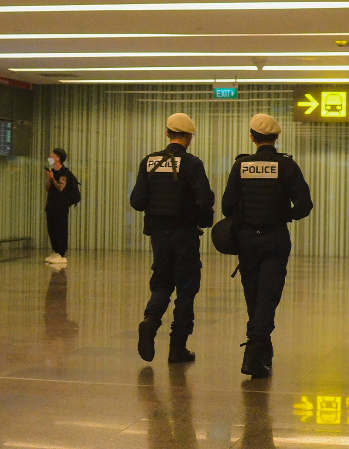 Police officers patrol an airport terminal after denied boarding incident involving a dog.