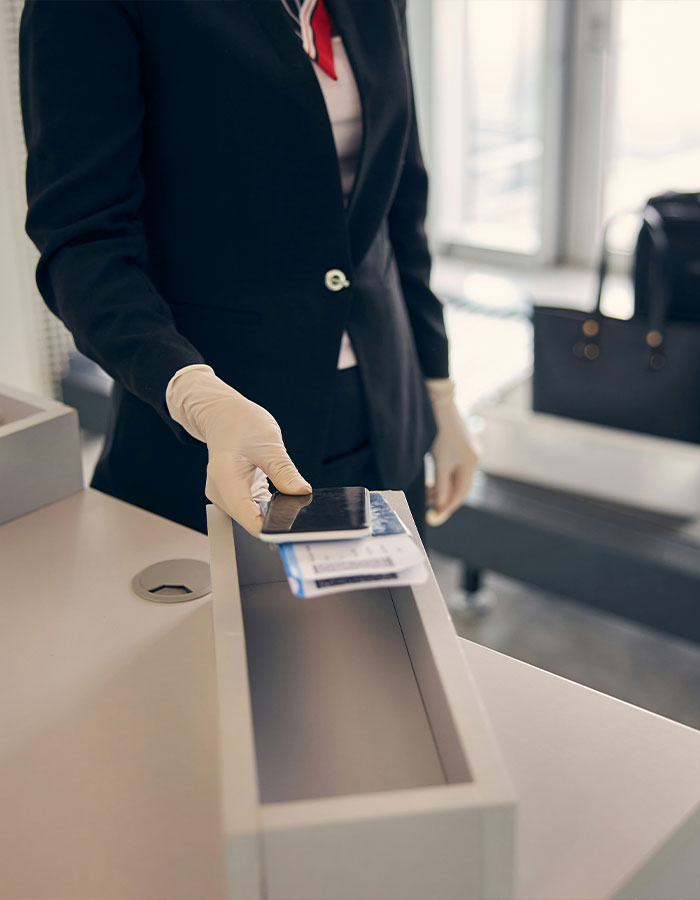 Airport security staff checking boarding pass and ID at gate counter.