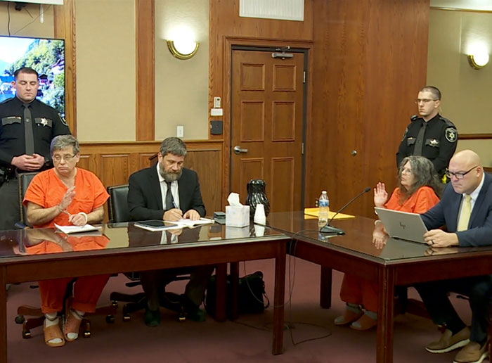 Courtroom scene with a couple in orange jumpsuits and attorneys, related to adopted kids and prison sentence. Courtroom scene with a couple in orange jumpsuits and attorneys, related to adopted kids and prison sentence.