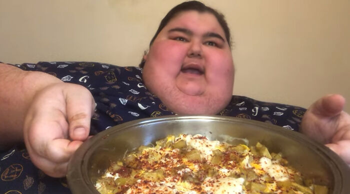 Person holding a dish with seasoned food, known for viral mukbang videos. Person holding a dish with seasoned food, known for viral mukbang videos.