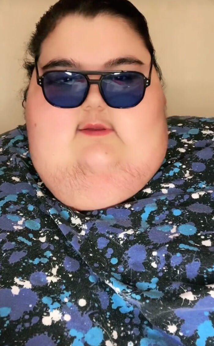 Mukbang video creator wearing sunglasses and a colorful patterned shirt. Mukbang video creator wearing sunglasses and a colorful patterned shirt.