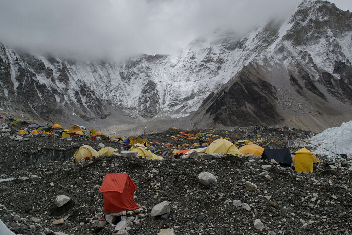 Colorful tents at a base camp with snow-capped mountains in the background, showcasing iconic places around the world.