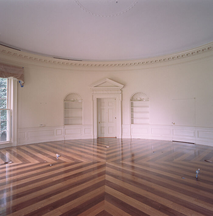 Empty Oval Office with patterned wood floor, highlighting an iconic place around the world.