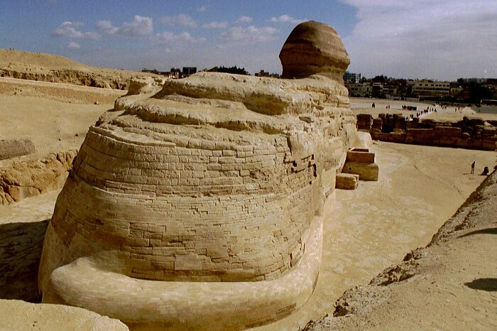 The Sphinx, iconic world landmark in Egypt, photographed from behind under a clear sky.