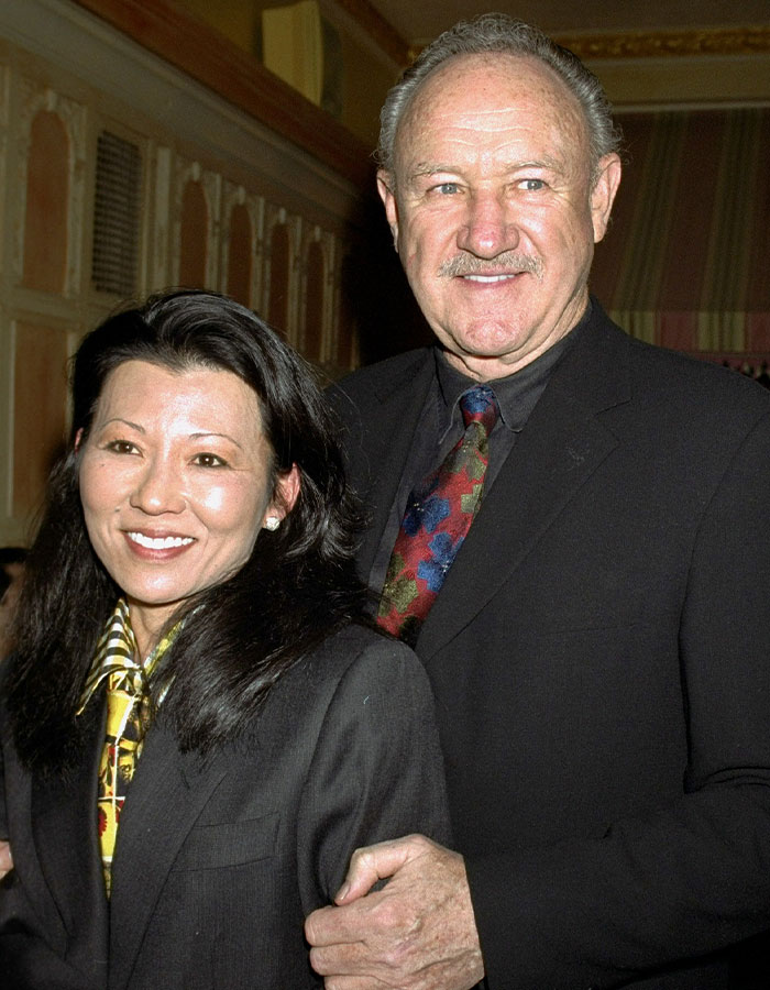 A smiling couple in formal attire at an event, focus on their expressions and outfits. A smiling couple in formal attire at an event, focus on their expressions and outfits.