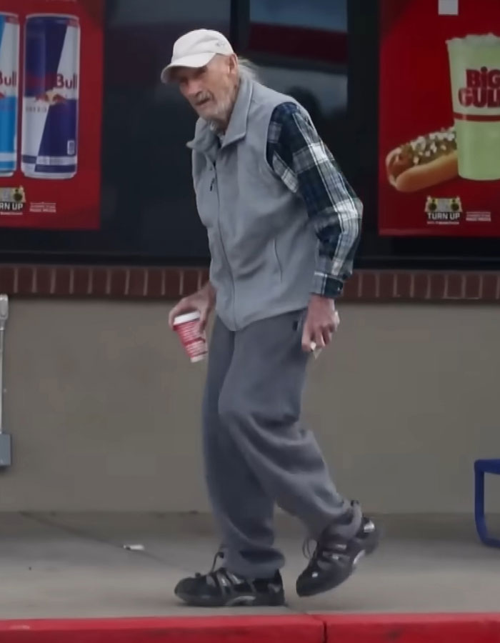 Elderly man in casual wear holding a drink, walking outside a store with energy drink ad. Elderly man in casual wear holding a drink, walking outside a store with energy drink ad.
