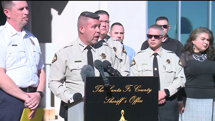 Police hold a press conference discussing Gene Hackman's pacemaker incident, with officers in uniform standing around. Police hold a press conference discussing Gene Hackman's pacemaker incident, with officers in uniform standing around.
