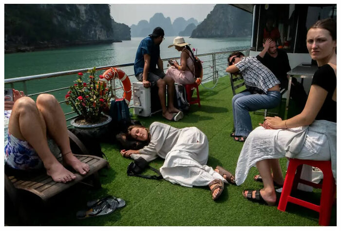 People relaxing on a boat with a scenic backdrop, captured by Andrés Ramos.