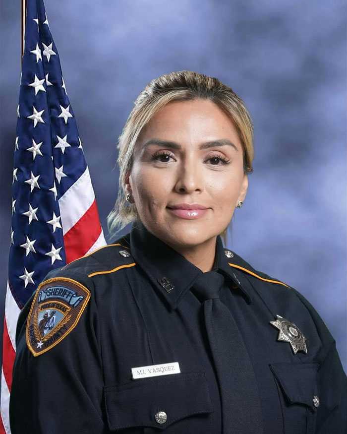 Texas Deputy in uniform with American flag backdrop.