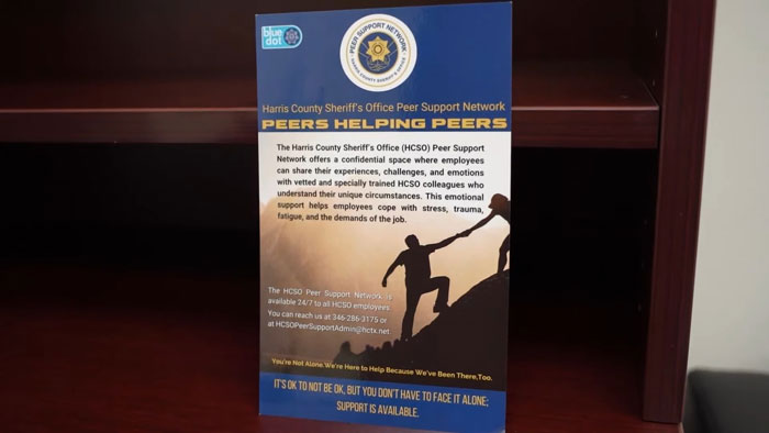 Texas police department peer support flyer on a desk, offering emotional help to officers in distress.