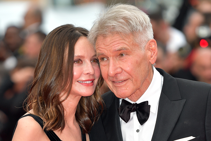 Harrison Ford and Calista Flockhart smiling at a formal event, wearing elegant attire.