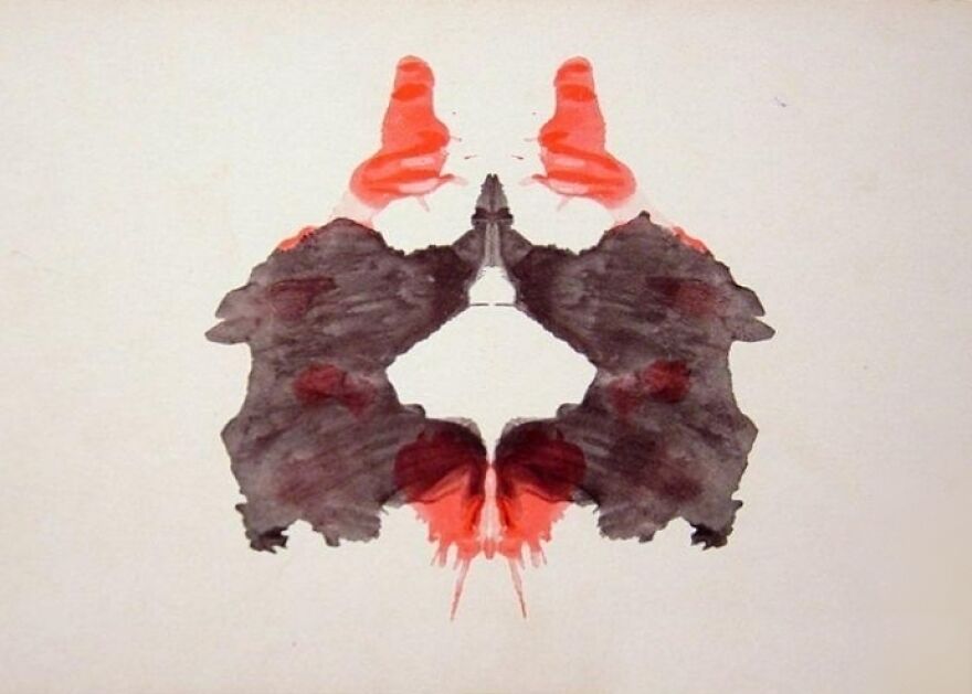 Rorschach inkblot test image with red and black symmetrical patterns for a psychological poll.