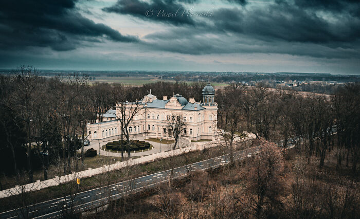 Aerial view of a grand building surrounded by trees and roads, highlighting the beauty of my city seen from above.