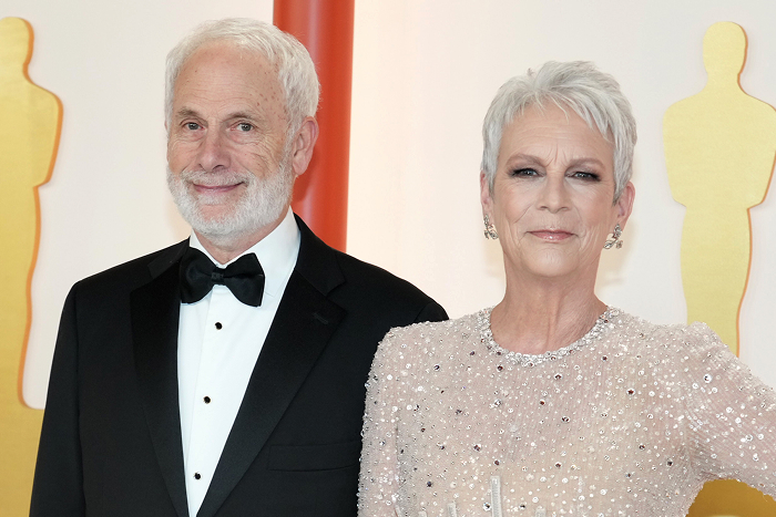 Jamie Lee Curtis and Christopher Guest on red carpet, with man in tuxedo and woman in glittering dress, showcasing celebrity couples together.