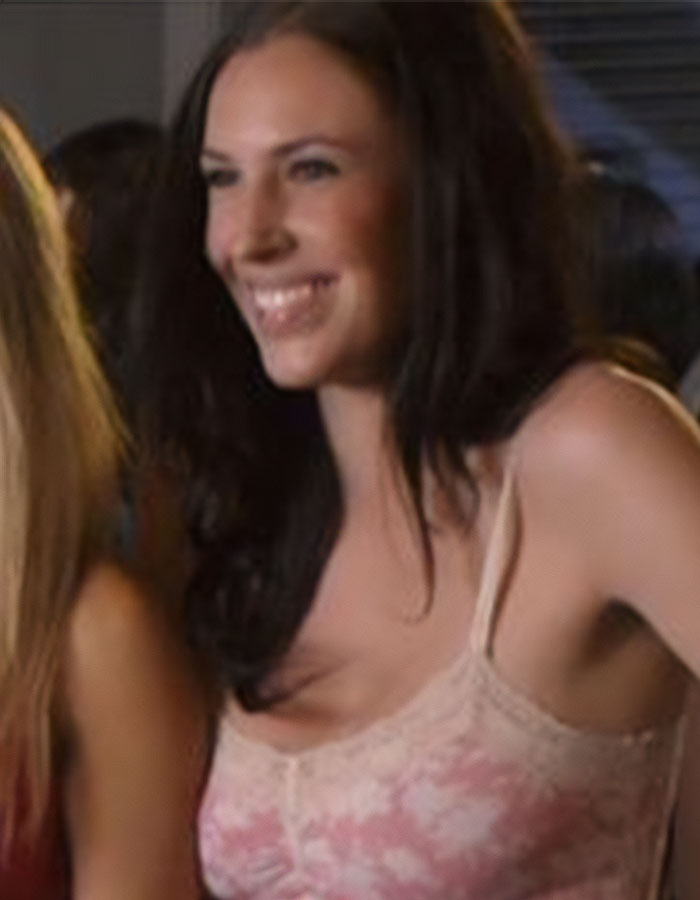 Smiling woman in a pink floral top, related to American Pie star's recent ICE release.