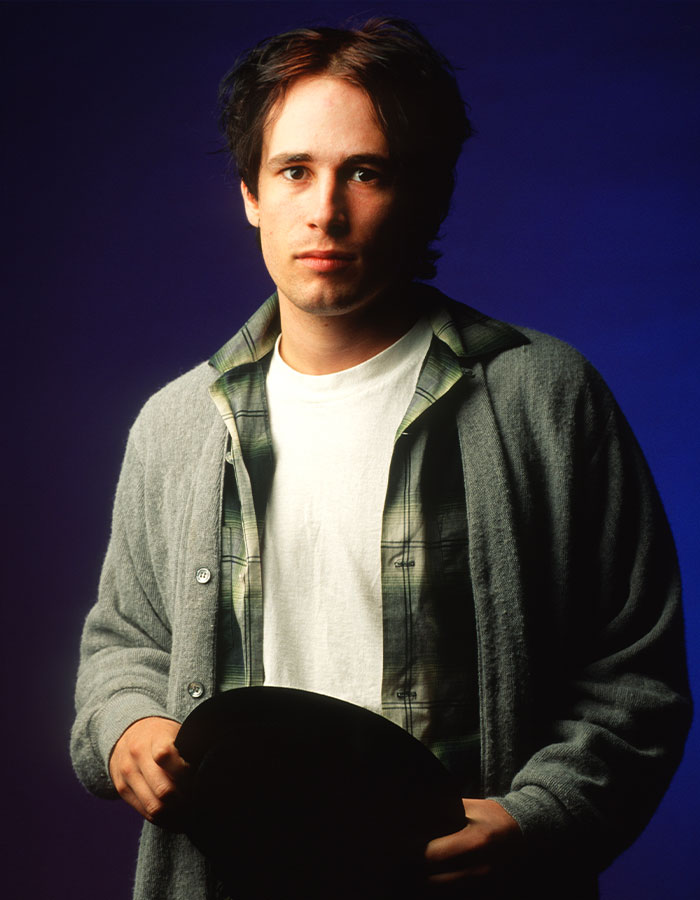 Young man in casual attire holding a hat, embodying the talent and potential of nepo babies.