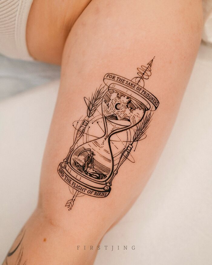 Fine-line tattoo of an hourglass with intricate, dreamy design on a person's arm.