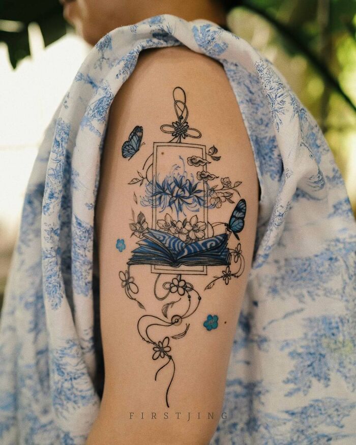 Fine-line tattoo of a dreamy scene with butterflies and flowers on a person's arm.