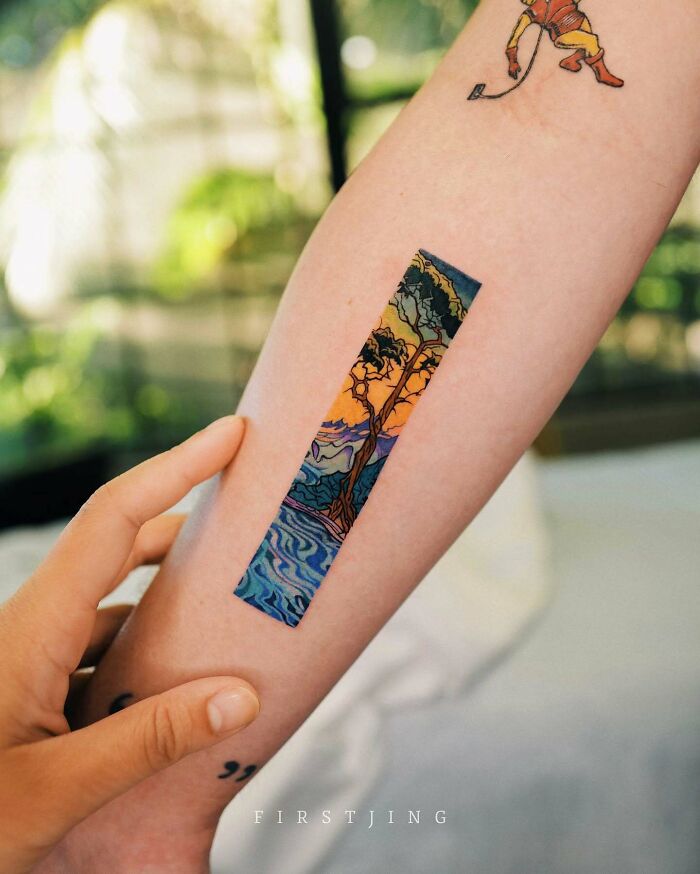 Fine-line tattoo on forearm depicting a colorful, dreamy landscape with trees and water.