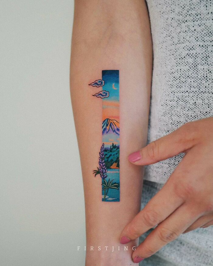 Fine-line tattoo on arm featuring a dreamy sunset landscape with mountains and clouds.