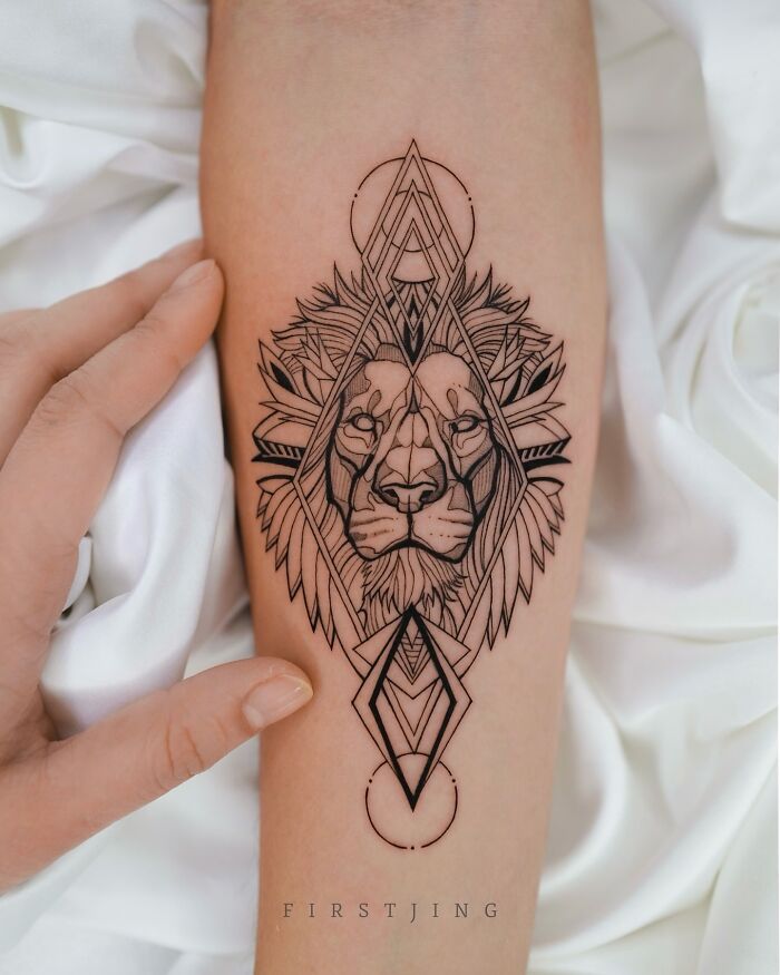 Fine-line tattoo of a geometric lion design on an arm, showcasing stunning artistry.