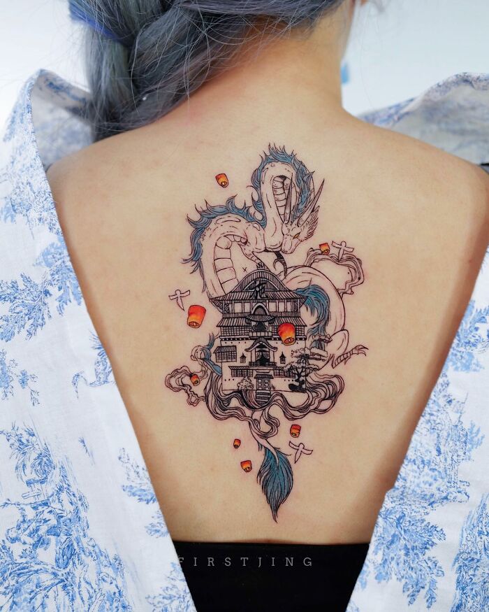 Fine-line tattoo depicting a dreamy dragon scene on a person's back.