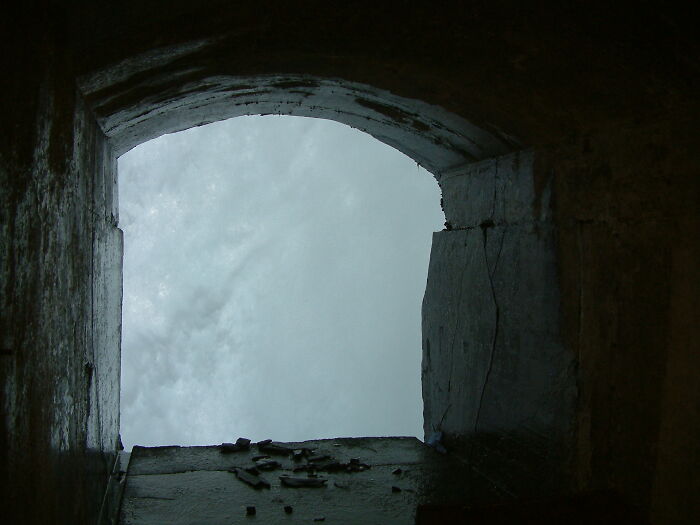 A view from behind a waterfall, iconic place with water cascading down, framed by a rocky arch.