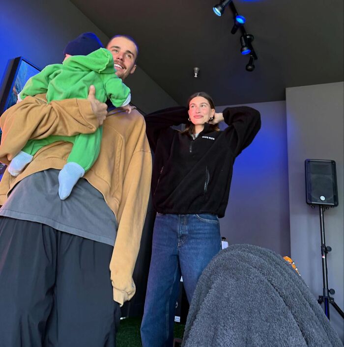 Man holding a child, with a woman nearby in a casual setting, highlighting concerns about Justin Bieber's health.
