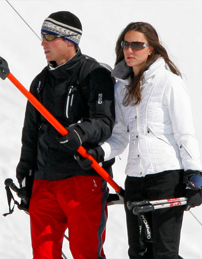 Young couple skiing in winter outfits, holding ski poles, highlighting pre-princess era photos of Kate Middleton.