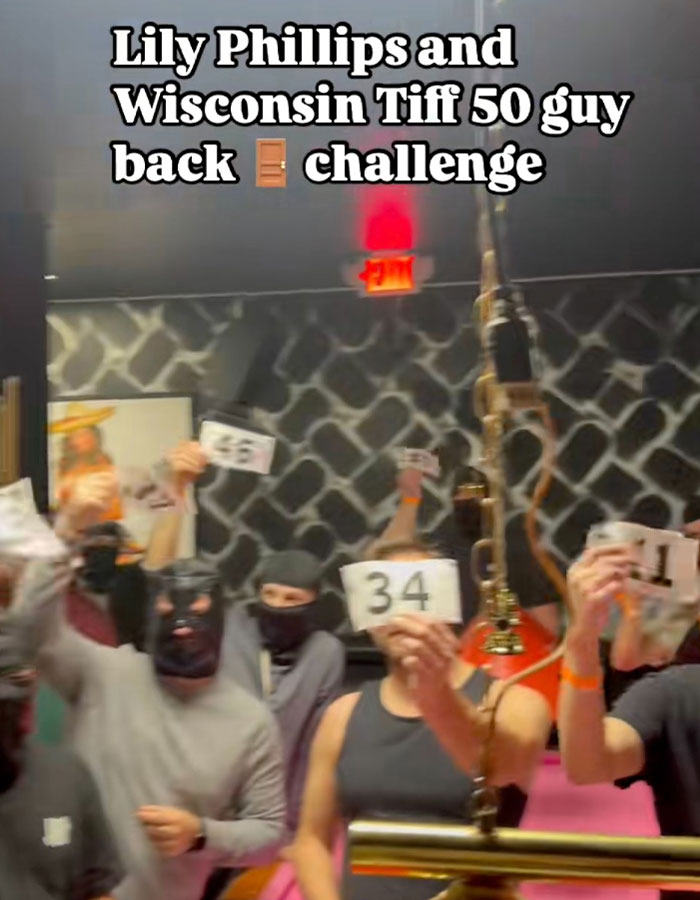 Group of masked men holding numbers during the controversial 50-men stunt by Lily Phillips.