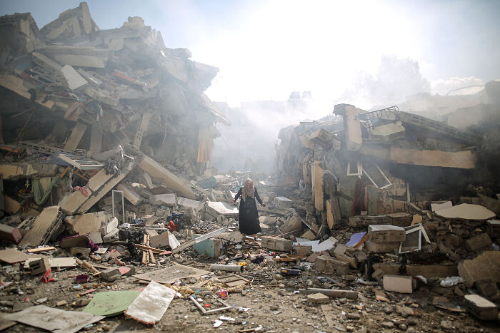 Person standing amidst rubble in a dramatic scene at the International Photography Awards 2024.