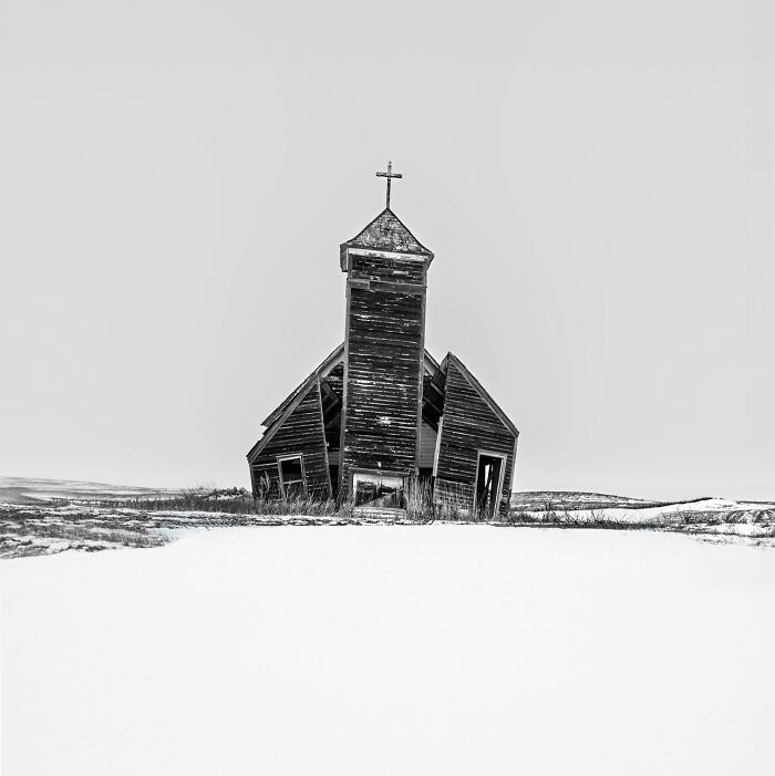A slanted, weathered church in a snowy landscape, captured at the 2024 IPA.