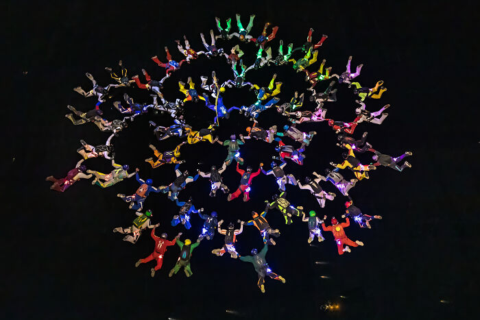 Aerial view of colorful skydivers in formation, showcasing a stunning photo from the 2024 IPA competition.