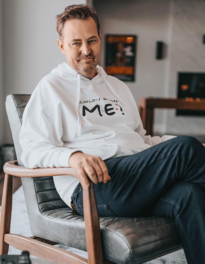 Man in white hoodie sitting on a chair, representing talented nepo babies theme in a cozy room setting.