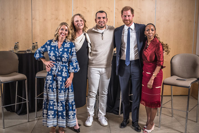 Group of five people at a charity event, including a man in a suit, standing together and smiling.