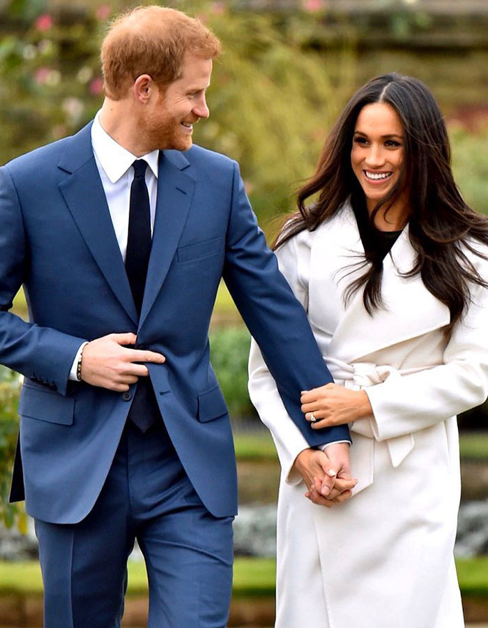 Couple smiling and holding hands, wearing formal attire outdoors, representing a public figure's charity event.