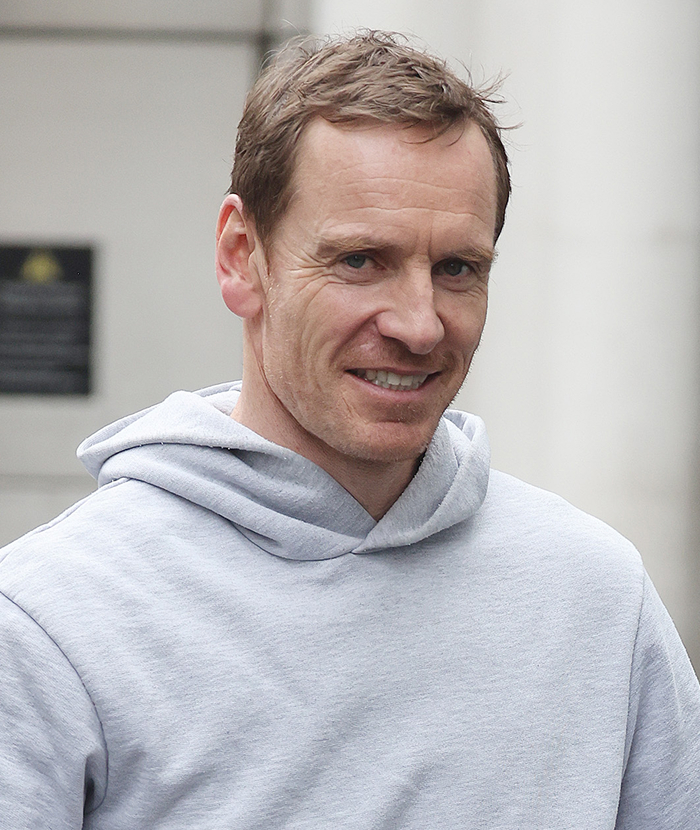 Man in a casual grey hoodie smiling outdoors, representing the attractiveness of celebrities in person versus on screen.