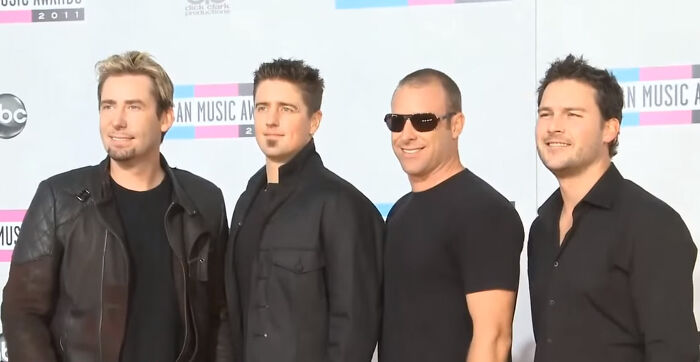Group of men at the American Music Awards 2011, standing in a line and smiling.