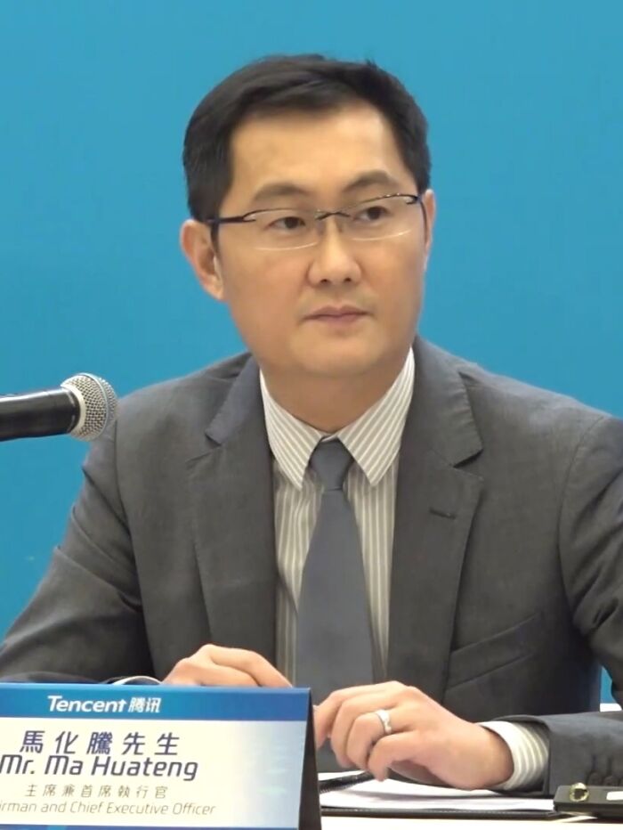 Businessman Ma Huateng speaking at a conference, representing one of the richest people with wealth surpassing countries.