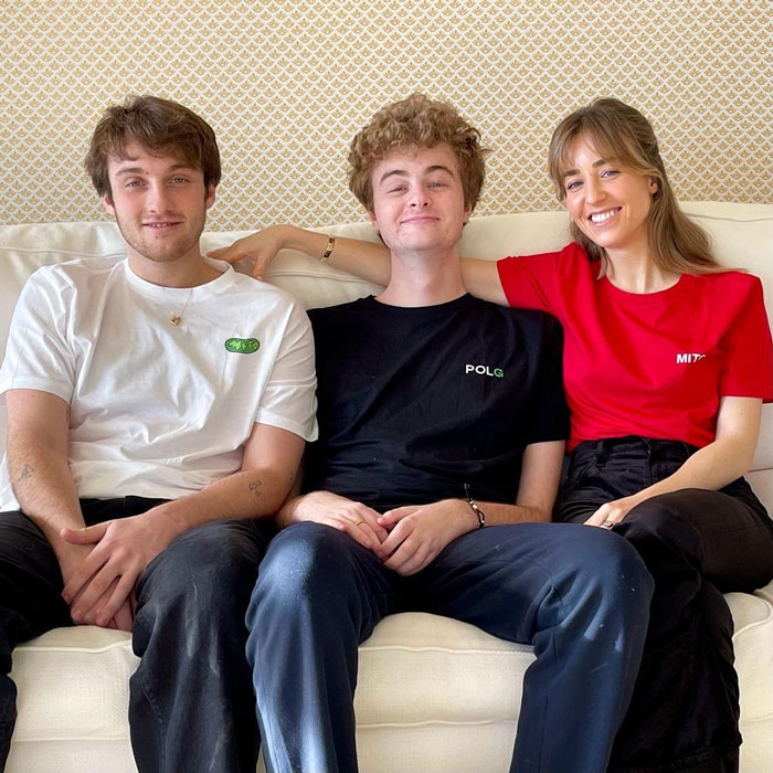 Three young adults sitting together on a sofa, smiling, with focus on Prince Frederik. Three young adults sitting together on a sofa, smiling, with focus on Prince Frederik.