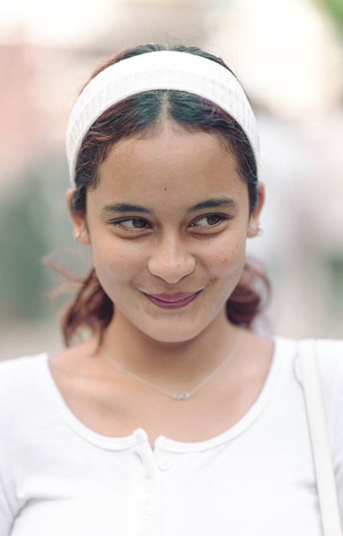 Portrait of a woman smiling shyly, captured by an Indian photographer showcasing beauty in strangers.
