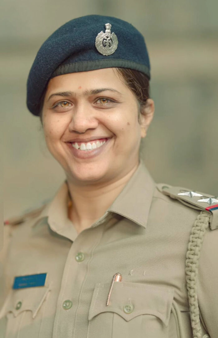 Smiling woman in uniform, an example of stunning portraits by an Indian photographer highlighting strangers' beauty.