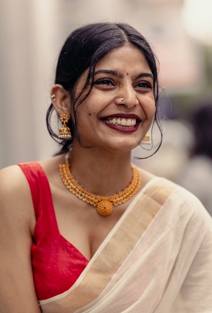 Smiling woman in a saree, captured by an Indian photographer, showcasing the beauty of strangers in portraits.