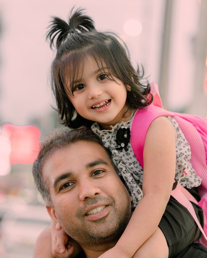 Father and daughter smiling for a portrait by an Indian photographer, showcasing the beauty of strangers.