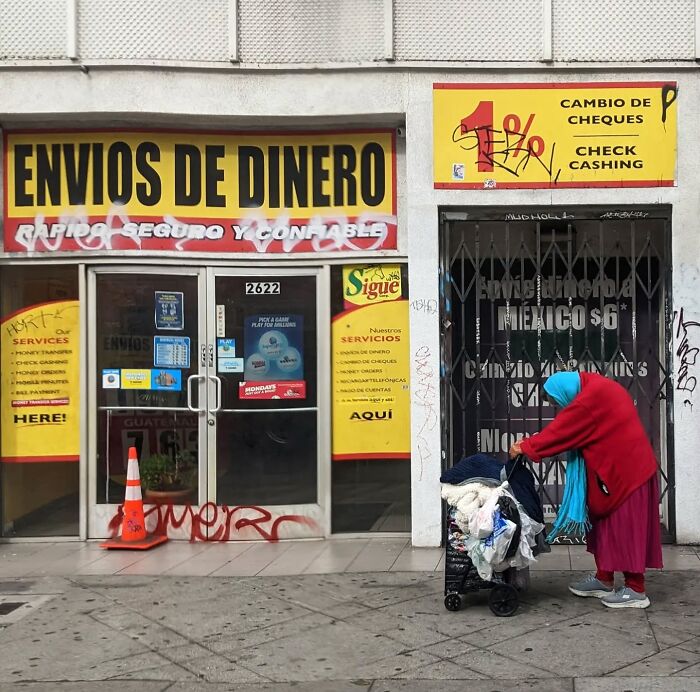 San Francisco street scene captured by Sage Akaboshi, featuring a money transfer shop and a person with a cart.